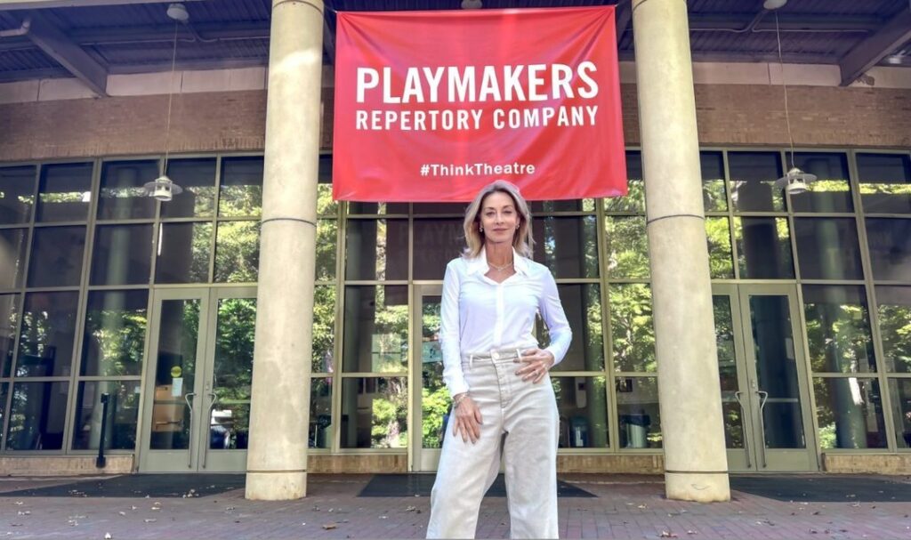Sharon Lawrence stands in front of PlayMakers Repertory Company sign.
