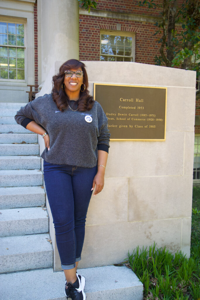 a woman stands on a set of stairs leading up to Carroll Hall