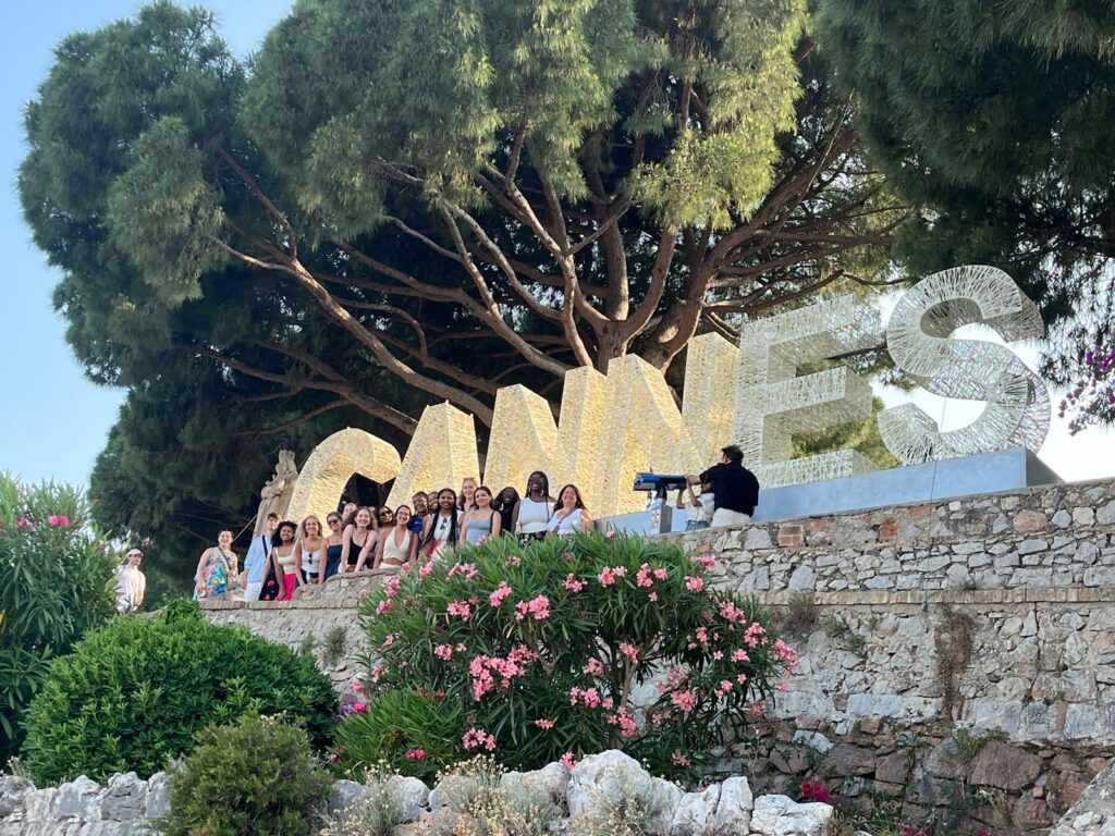 a group of students in front of a Cannes sign