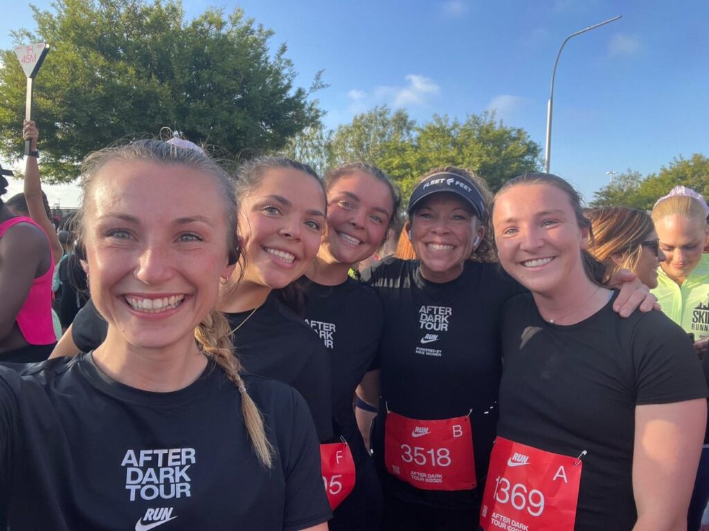 five runners smile after a race