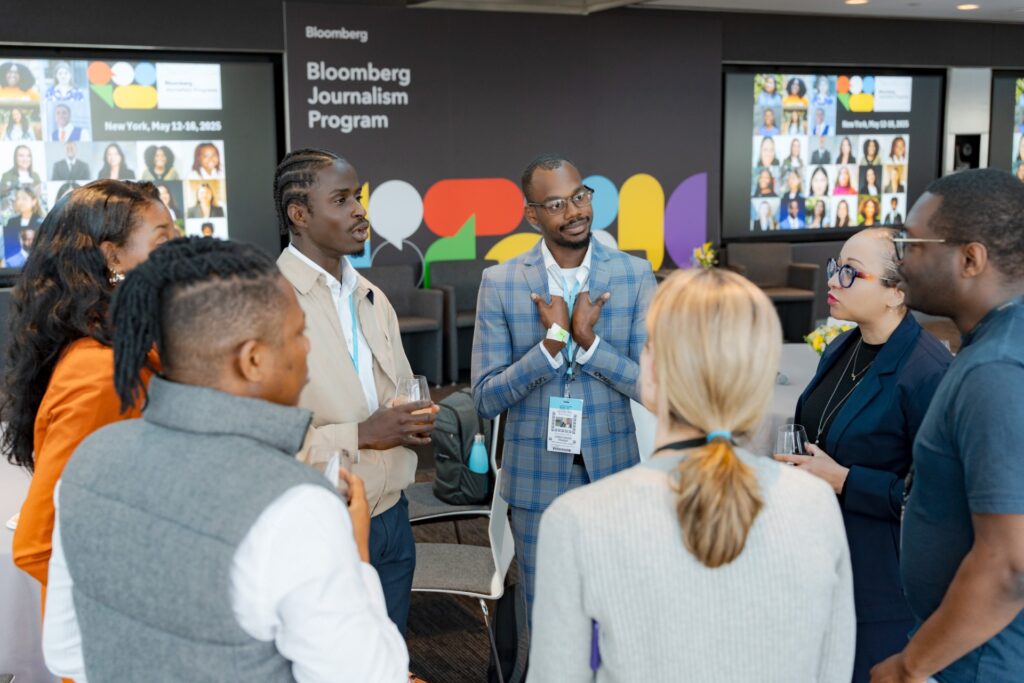 a small group of students and advisers stand in a circle while at the Bloomberg Journalism Program