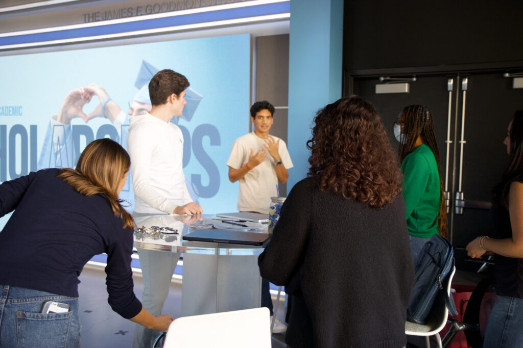 a man speaks to four students in the broadcast studio