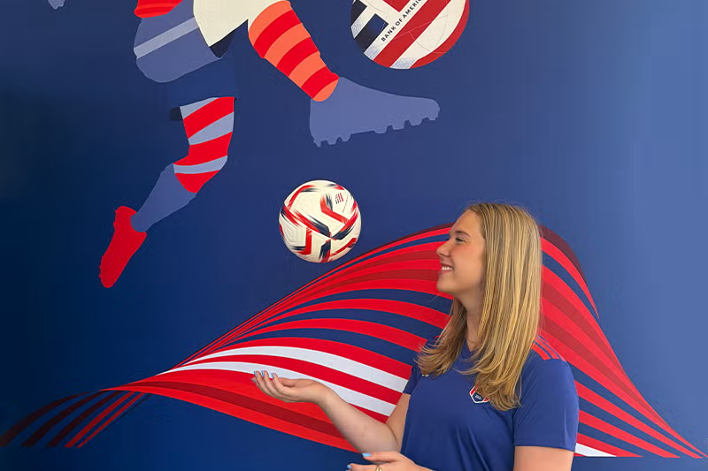 Emily Cancro stands in front of soccer wall.