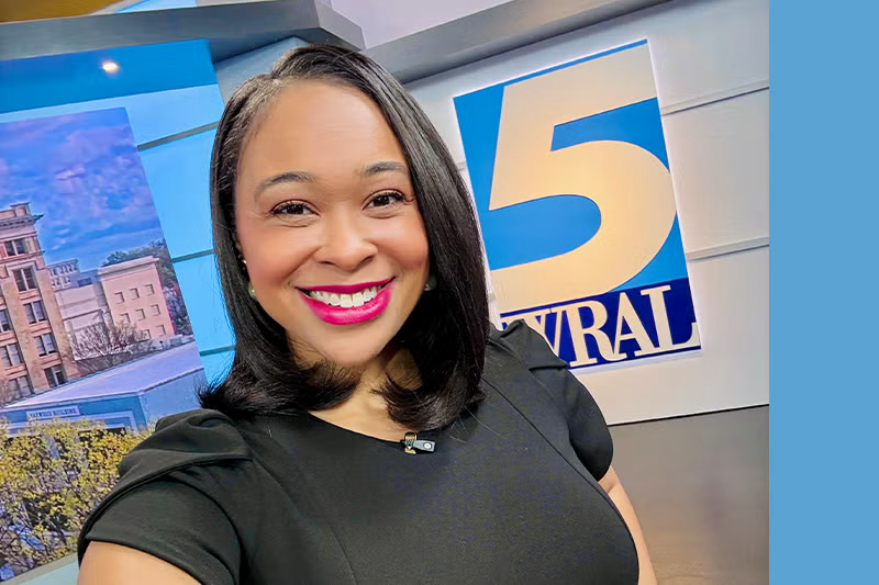 Kirstyn Clark stands in front of WRAL sign in the studio.