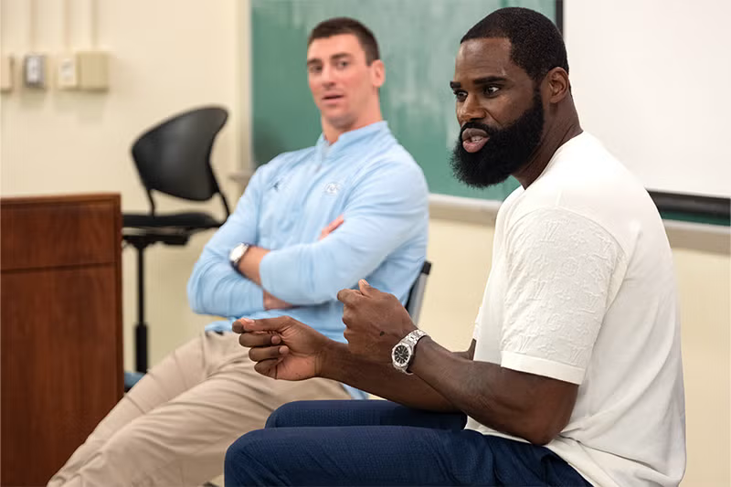 Tyler Hansbrough looks towards Antawn Jamison in a classroom.
