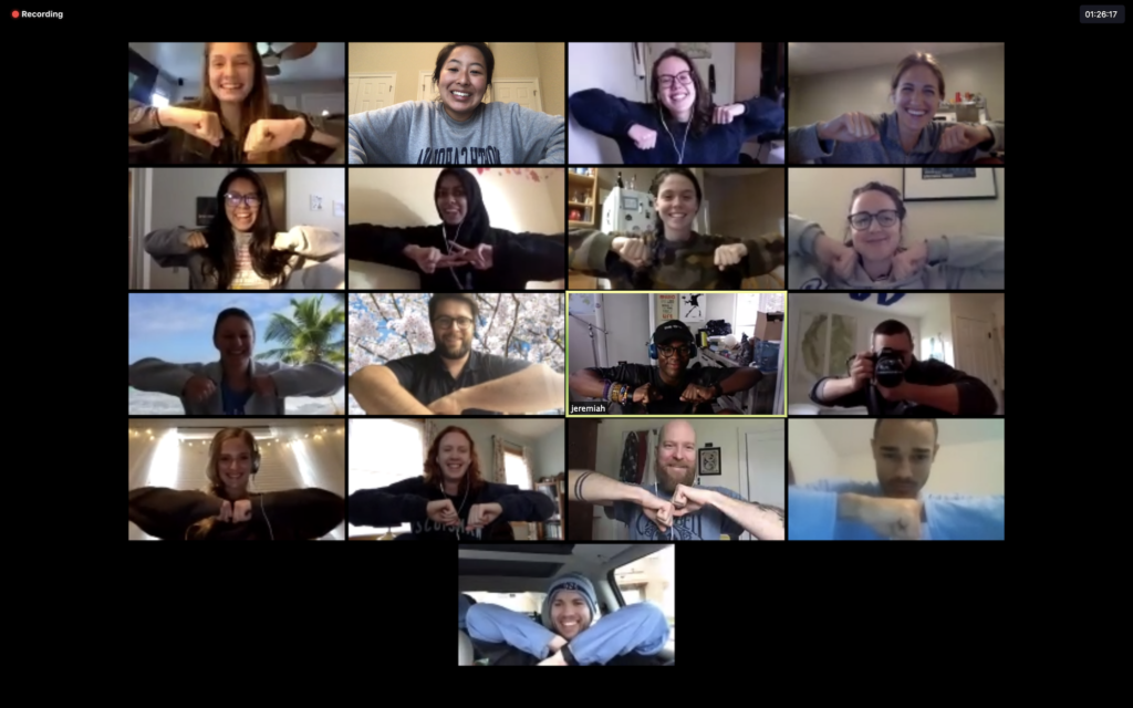 a photo of several students and a professor holding the same pose on a Zoom call